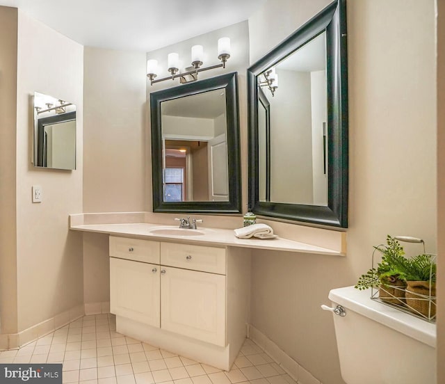 bathroom with tile patterned flooring, toilet, vanity, and baseboards