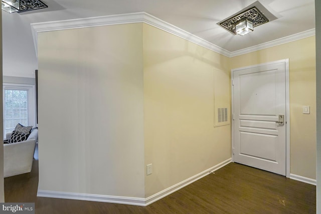 hall with dark wood finished floors, visible vents, baseboards, and ornamental molding