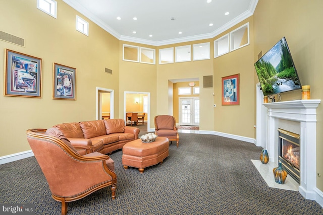 carpeted living area with visible vents, a fireplace with flush hearth, and ornamental molding