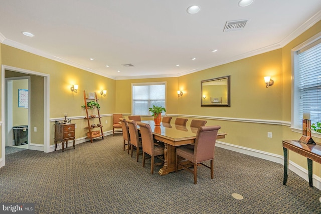 dining room featuring baseboards, carpet, visible vents, and ornamental molding