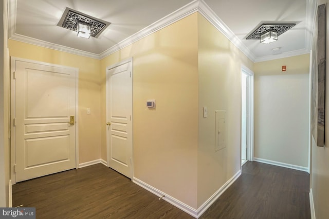 hallway featuring baseboards, dark wood-style floors, visible vents, and ornamental molding