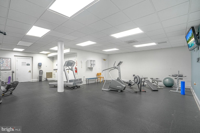 workout area with a drop ceiling and baseboards