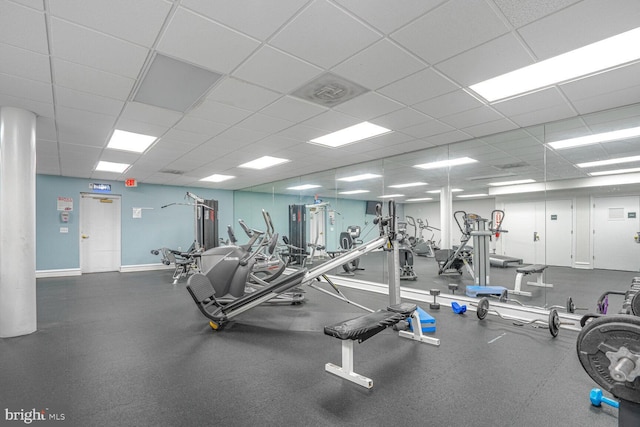 exercise room with visible vents, baseboards, and a drop ceiling