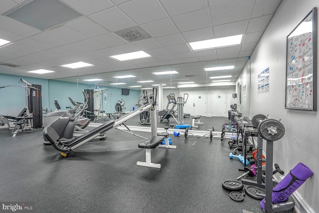 exercise room with a paneled ceiling and visible vents