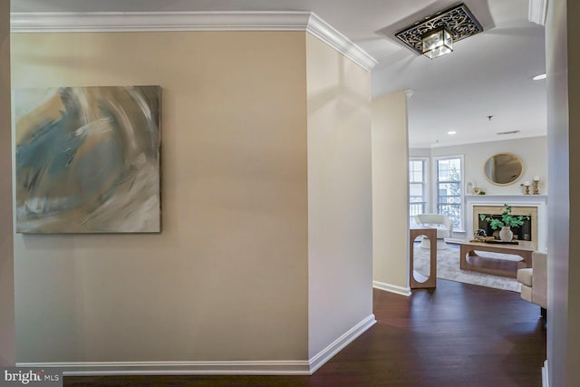 corridor with dark wood finished floors, recessed lighting, baseboards, and ornamental molding