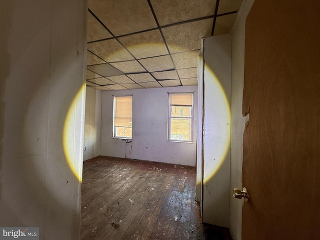 unfurnished room with a paneled ceiling and wood-type flooring