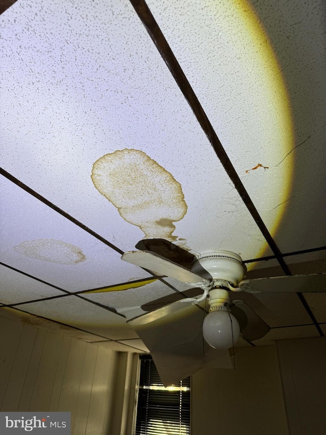 interior details with a paneled ceiling and ceiling fan