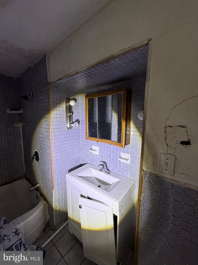 bathroom featuring vanity, tile walls, shower / bathtub combination, and tile patterned flooring