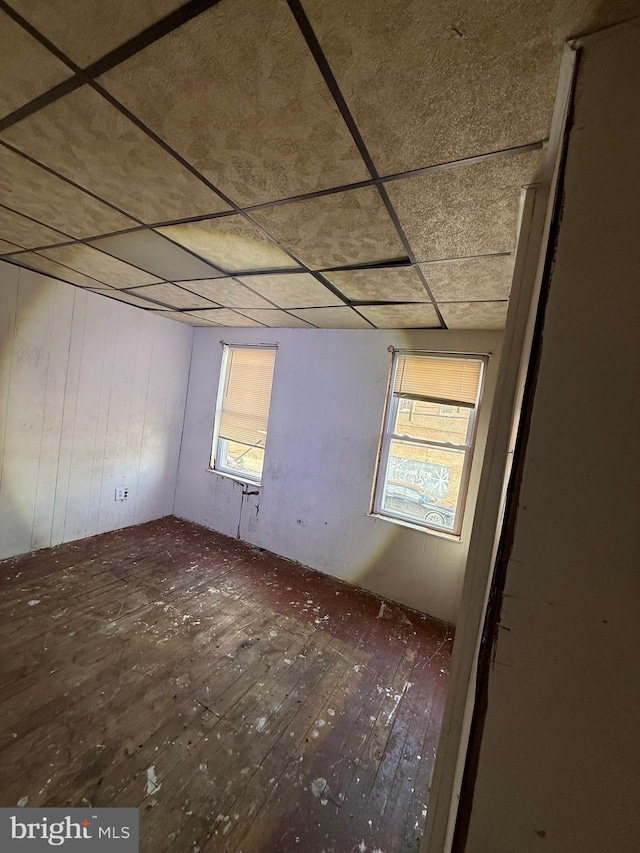 spare room featuring a paneled ceiling and wood-type flooring