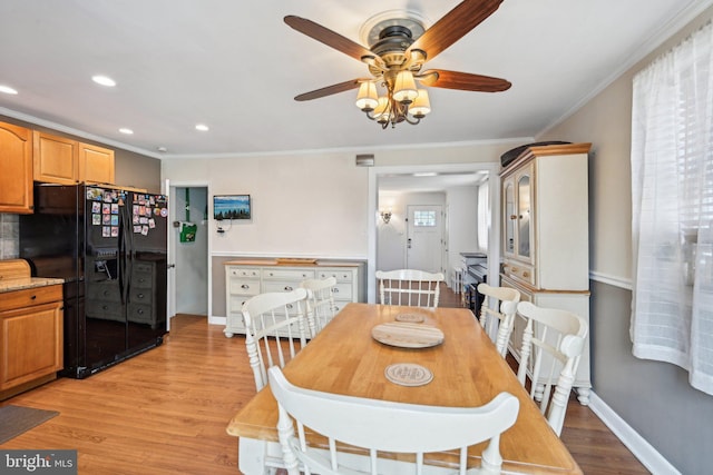 dining space with recessed lighting, crown molding, light wood-style flooring, and baseboards