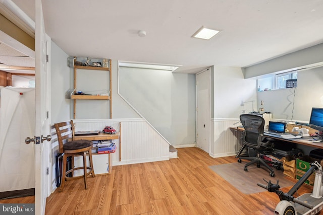 home office featuring a wainscoted wall and wood finished floors