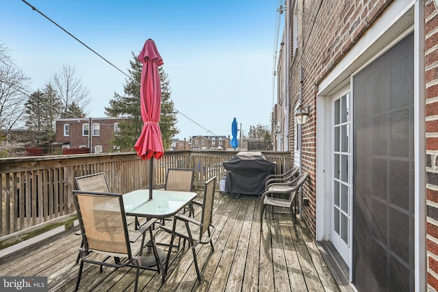 deck featuring outdoor dining area and area for grilling