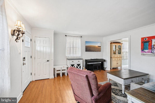 living room featuring light wood-type flooring, baseboards, and crown molding