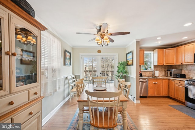 dining area featuring light wood-type flooring, french doors, crown molding, and baseboards