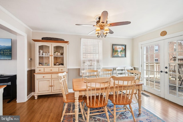 dining space with ornamental molding, wood finished floors, and visible vents