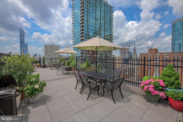 view of patio / terrace featuring a view of city, outdoor dining area, and cooling unit