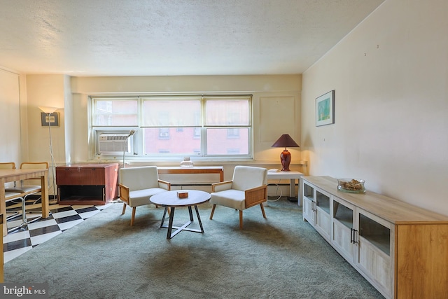 living area with a wealth of natural light, cooling unit, and a textured ceiling