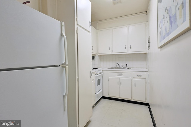 kitchen with white appliances, light countertops, a sink, and white cabinetry