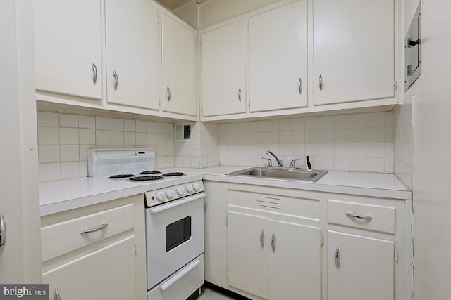 kitchen with white range with electric stovetop, light countertops, a sink, and decorative backsplash