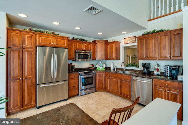 kitchen featuring visible vents, brown cabinets, stainless steel appliances, a sink, and recessed lighting