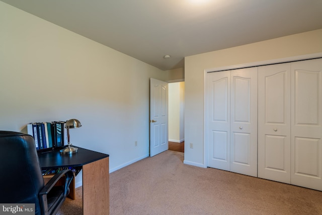 carpeted home office featuring baseboards