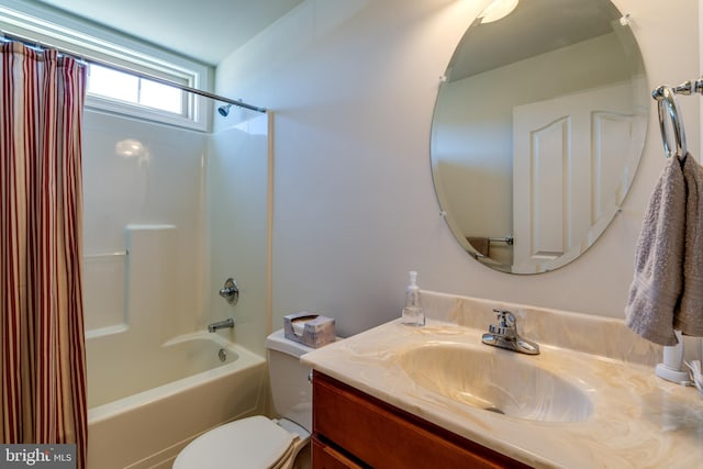 bathroom featuring toilet, shower / bath combo with shower curtain, and vanity