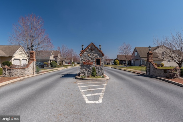 view of road featuring sidewalks, street lighting, a residential view, and curbs