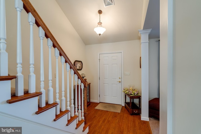 entrance foyer featuring stairway, wood finished floors, visible vents, and baseboards