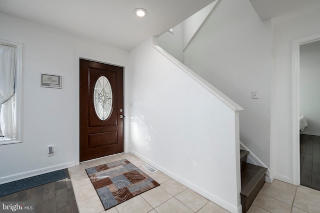 foyer entrance featuring recessed lighting, stairway, baseboards, and light tile patterned flooring