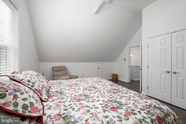 bedroom with a closet, lofted ceiling, dark wood-type flooring, and ceiling fan