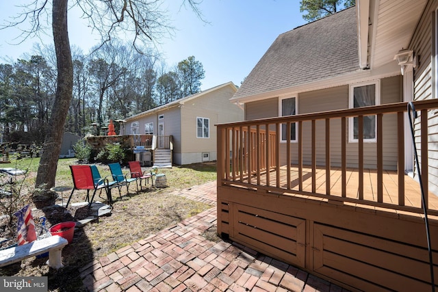 exterior space with a wooden deck and a shingled roof