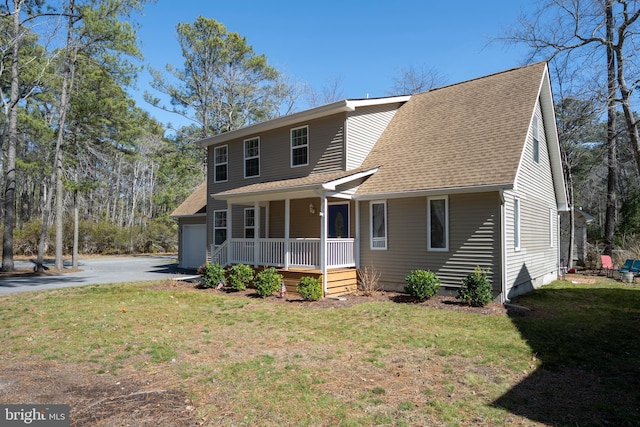 view of front of house featuring driveway, roof with shingles, a porch, and a front yard