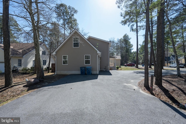 view of side of home featuring aphalt driveway