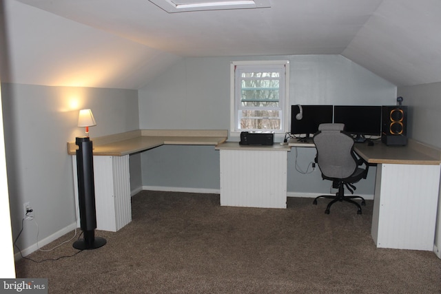 unfurnished office with dark colored carpet, baseboards, lofted ceiling, and built in study area