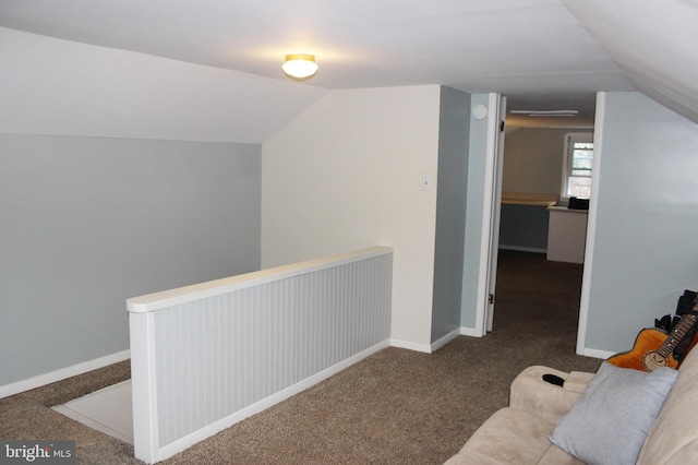 additional living space with baseboards, carpet flooring, and vaulted ceiling