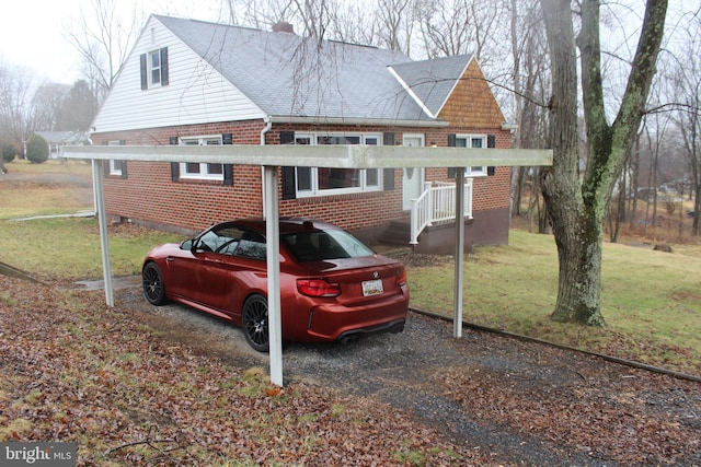 view of side of property featuring a detached carport, a yard, brick siding, and a chimney