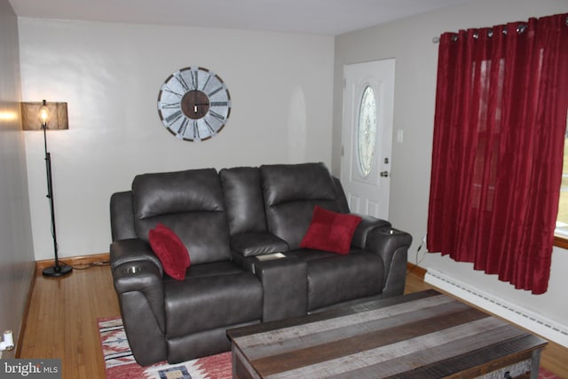 living room featuring baseboard heating, baseboards, and wood finished floors