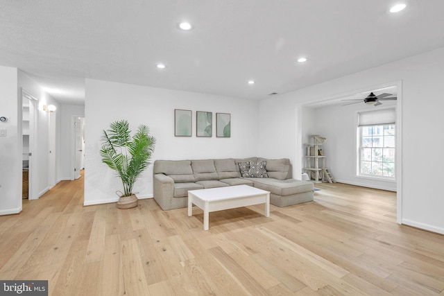 living room featuring light wood-type flooring, baseboards, and recessed lighting