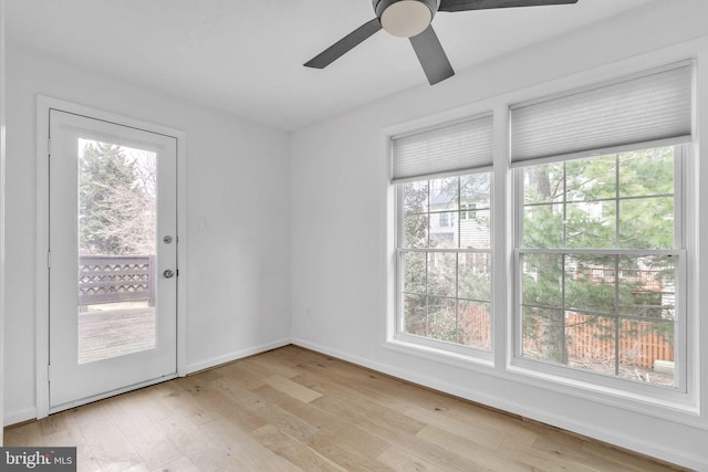 interior space featuring ceiling fan, light wood-type flooring, and baseboards