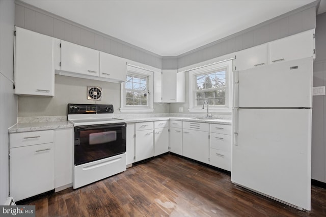 kitchen featuring dark wood-type flooring, range with electric stovetop, a sink, light countertops, and freestanding refrigerator