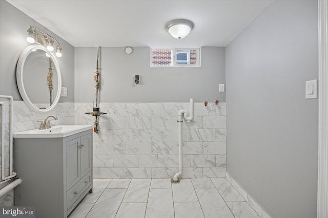 bathroom with wainscoting, tile walls, and vanity