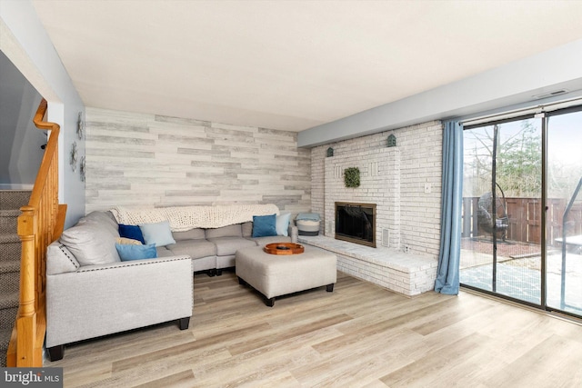 living room featuring a fireplace, wood finished floors, and stairs