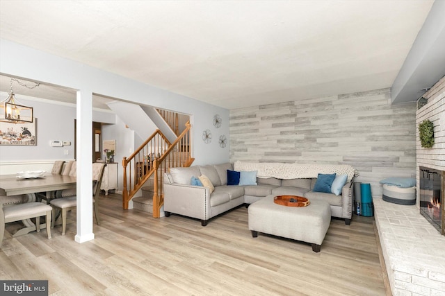 living area with stairway, light wood-style flooring, and a fireplace