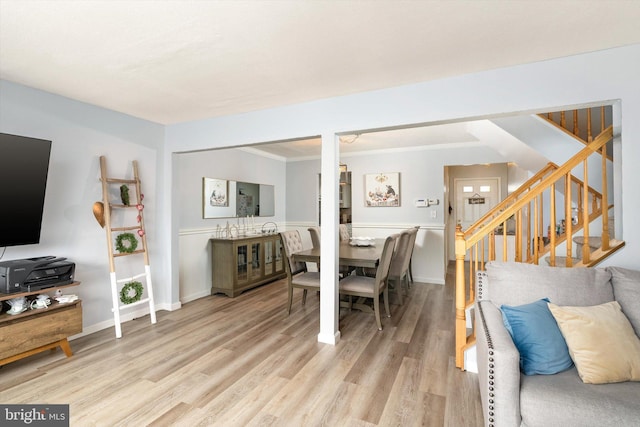 living area featuring ornamental molding, stairs, baseboards, and wood finished floors