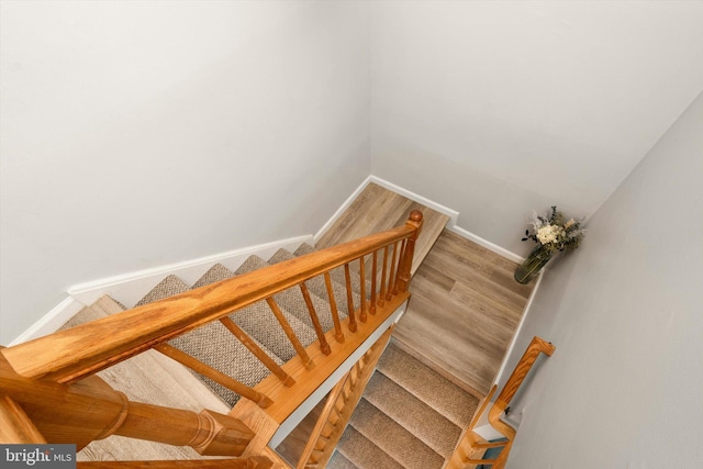 stairway featuring baseboards and wood finished floors