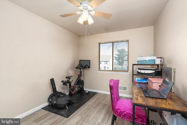 office space featuring visible vents, ceiling fan, baseboards, and wood finished floors