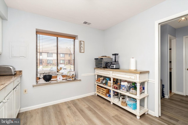 misc room with visible vents, baseboards, and light wood finished floors