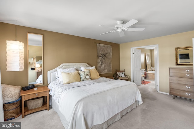 carpeted bedroom with connected bathroom, baseboards, and ceiling fan