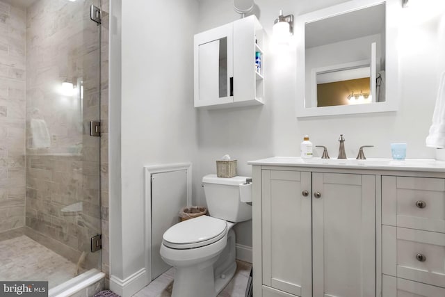 full bath with toilet, a shower stall, baseboards, and vanity