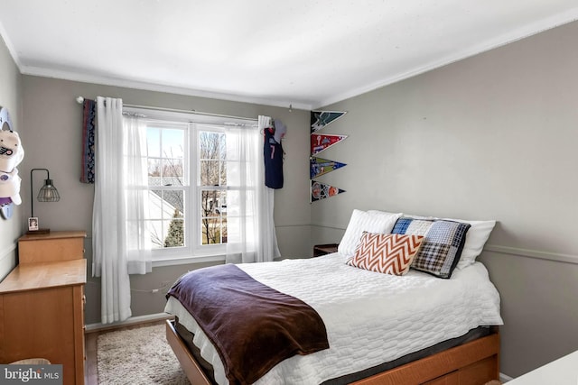 bedroom with ornamental molding and baseboards